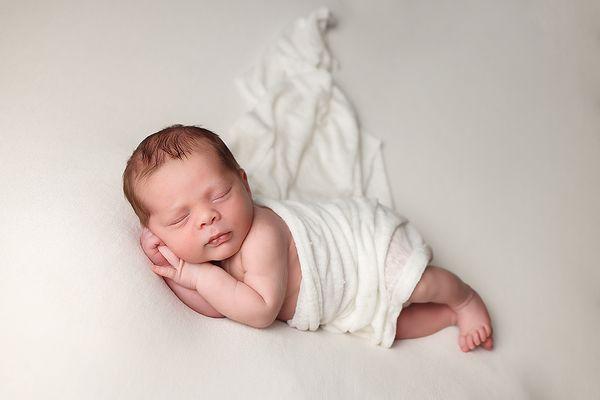 Newborn Portrait of baby boy in ivory wrap.