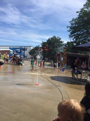 Splash pad/outdoor tables near stage area provide shade.