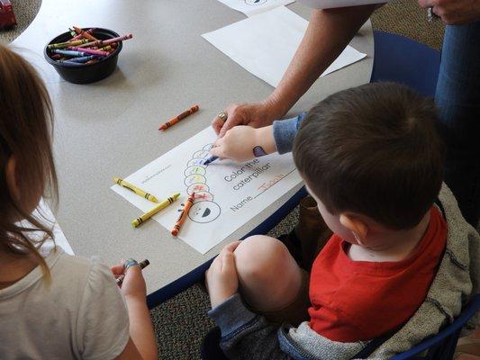 Practicing fine motor skills by coloring in The Hungry Caterpillar