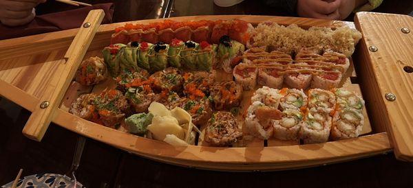 6 sushi rolls are served in a cool wooden boat