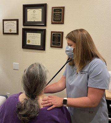 Dr. Tabor-Manaker listening to a patient's heart and lungs.