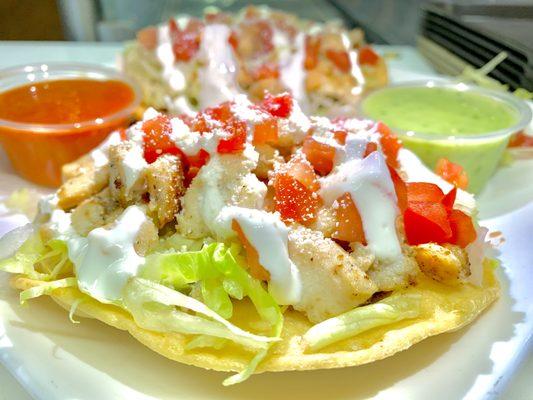 Chicken Tostadas topped with lettuce, tomato, sour cream and cheese