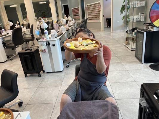 Kelsey holding citrus slices and enhancements for pedicure!