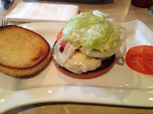 Bacon burger with everything on it. Two tomatoes. Two pickles, bacon and lettuce.