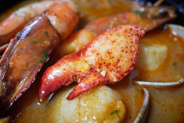 Seafood Bouillabaisse - lobster claw, Kauai prawns, diver scallops, clams in a thai spice lobster broth mounted with brandy butter