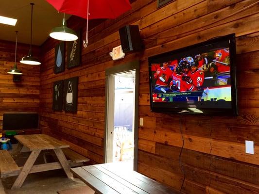 A couple TVs and an outdoor area with some chairs.