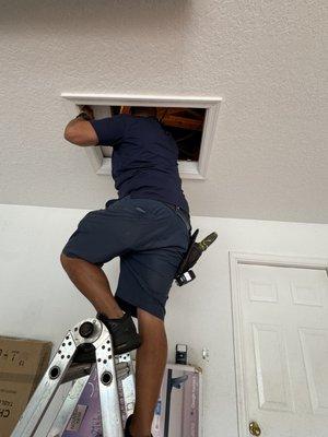 Our Chief Inspector at a residential location going into attic for roof inspection.