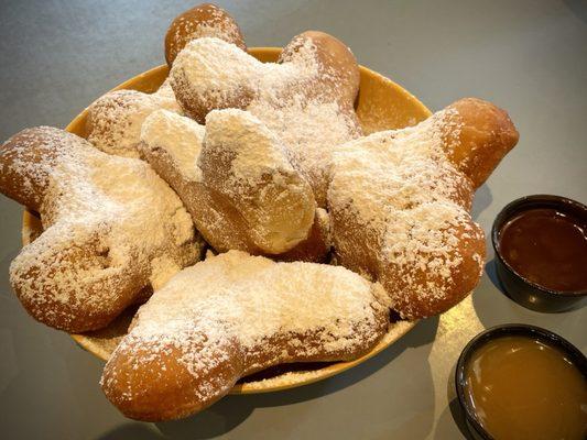 Six fresh Mickey Beignets ($11.29) with salted caramel and chicory-chocolate sauces.