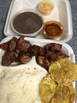 Grio (fried pork), white rice, fried plantains, black bean sauce, Haitian sauce.