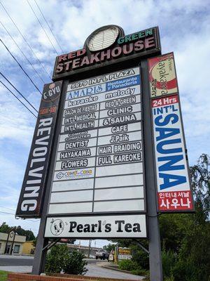 Outside. Street sign. Red and Green Brazilian Steakhouse is located in International Plaza on Buford Highway OTP.