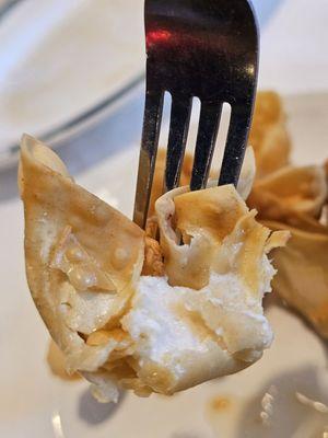 A close-up of a fork holding a piece a Crab Rangoon appetizer. So fresh and appetizing.