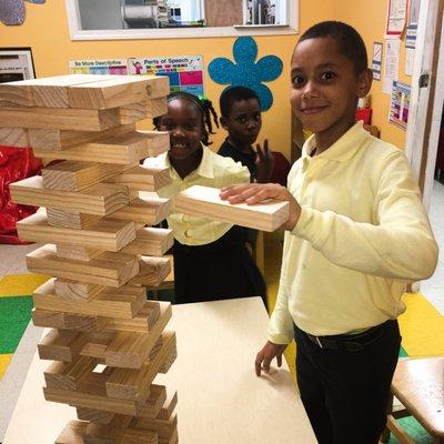 A few students playing jenga together in the center after school.