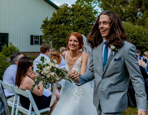 Wedding photo of couple walking down the aisle.