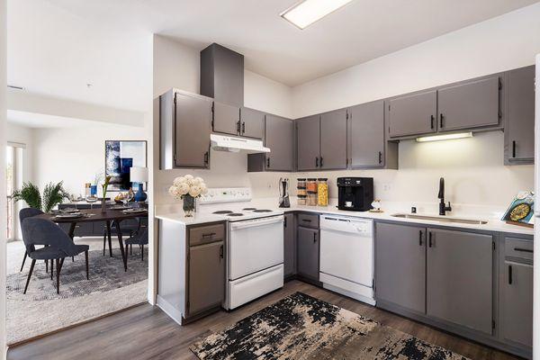 Shoreline Village Apartments in Richland, WA - Newly renovated kitchen with gray cabinets and faux wood flooring, looking into dining area.