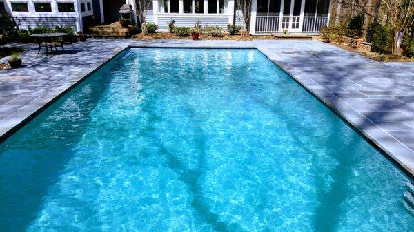 Plaster color, sunlight, shading and water quality are all factors in the water appearance.