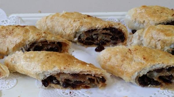 A Caribbean pastry with a blend of cinnamon spices, sugar and raisins rolled up in a flaky pastry dough baked and cut to the desired size.