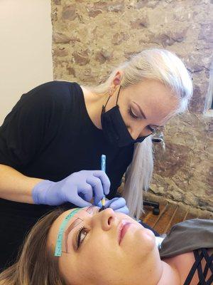 Mapping clients eyebrows for microblading.