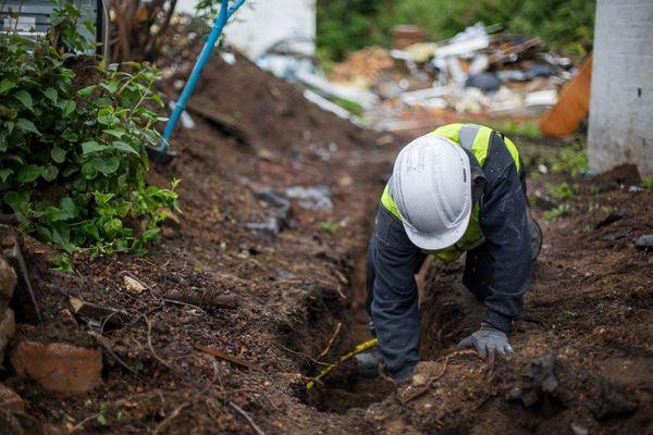 Crew digging to install a french drain for foundation maintenance