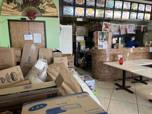 Junk, drinks, and containers, piled in front of a non-working restroom.