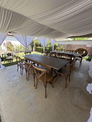 Draped tent, farm tables and cross back chairs