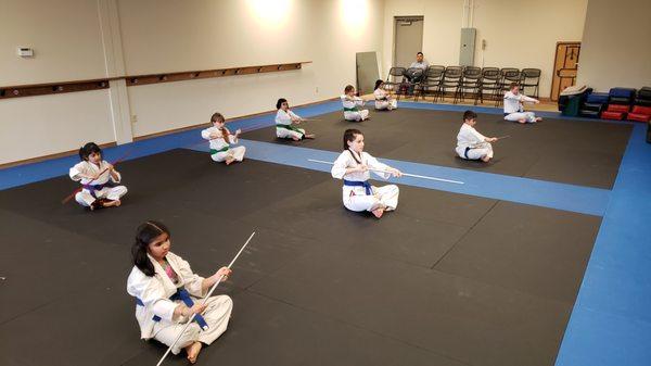 Practicing Bo form in our intermediate martial arts class for 6 to 12 year olds