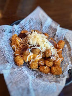 Game Day Tatchos Tater tots, beer cheese, nacho cheese, shredded cheese, brats, sauerkraut