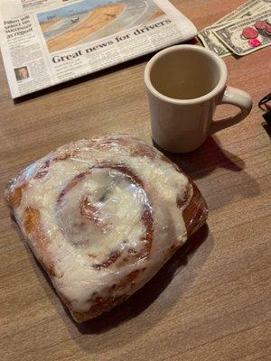 Cinnamon roll with coffee cup for size