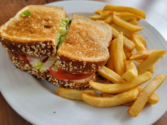 Buffalo chicken sandwich on bread with fries