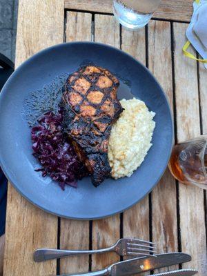 Grilled Pork chop With red cabbage Carsen Mills white cheddar grits in applewood bacon jus