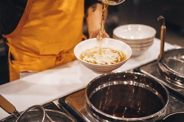 Udon broth being poured in