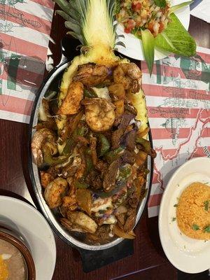 Fajitas " cinco de mayo". Shrimp, chicken and steak fajitas on a pinneaple and flambeé.