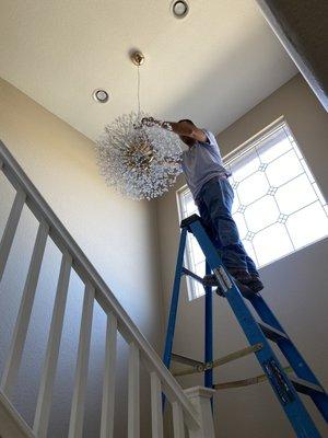 Jesus Jaime installing upper level chandelier.