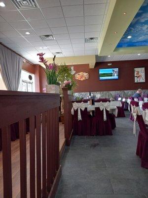 Platform with long table for a large party next to front windows.