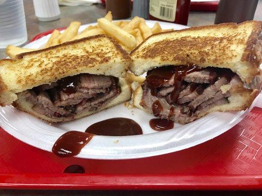 Beef brisket sandwich with a side of French fries.