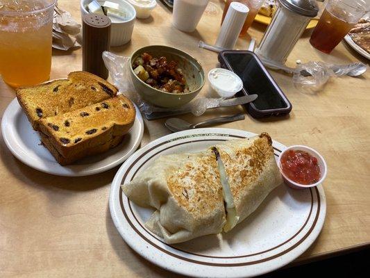 Philly breakfast burrito with a side of cinnamon raisin toast and fried potatoes