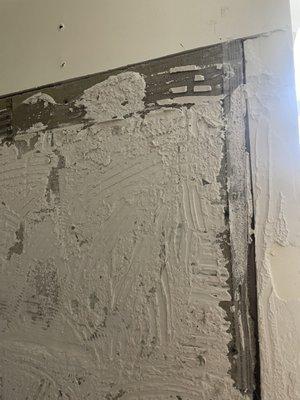 The drywall in shower after tile had to be taken down showing gaps around the edge, irregular, inconsistent tile cement