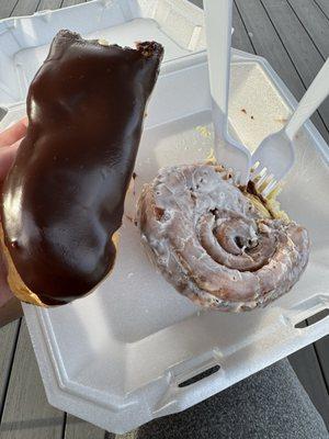 Cinnamon bun and eclair (partially eaten )