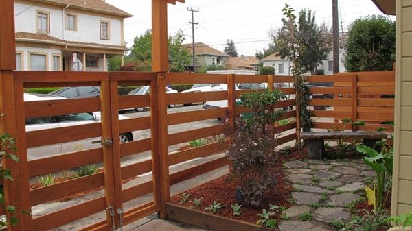 Horizontal fence and gate.  Arbor.  Mailbox and lettering.  Stone bench, flagstone, water fountain.