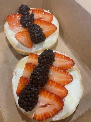 Bagel with cream cheese, honey, strawberries and blackberries.