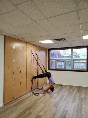 A student experiencing The Yoga Wall and how yoga on the wall can help alleviated neck and back pain.