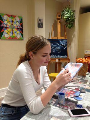 One of our teenagers glazing a ceramic plate she made in class