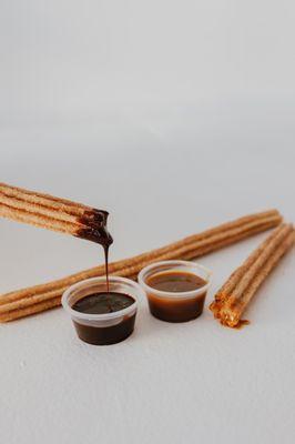 Warm churros are delicious dipped in chocolate or caramel.