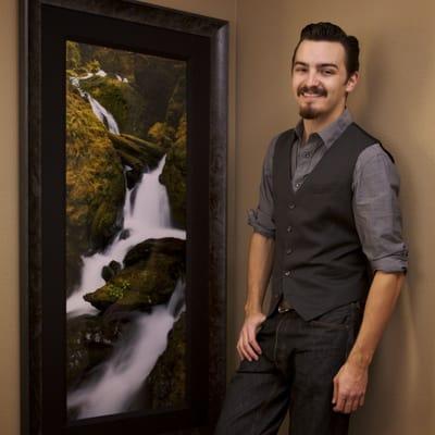 Nick Carver next to one of his framed artworks.