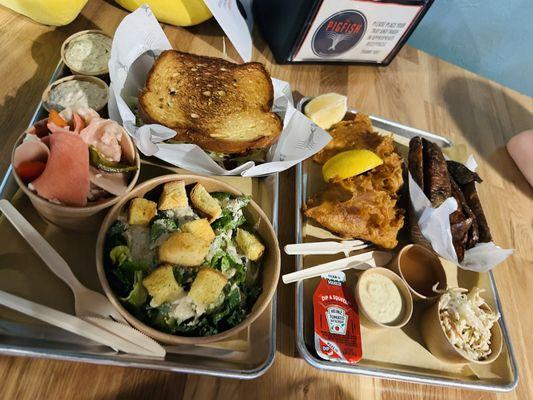 Nashville style fish sandwich, pickled things, Caesar salad and fish and chips.