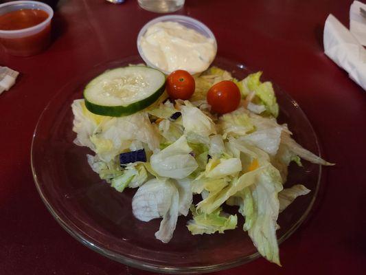 Side salad with cucumber dressing served on the side as ordered