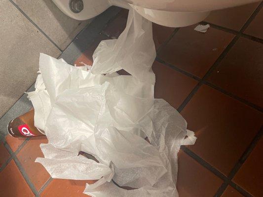 How long has this pile of trash been sitting next to the toilet...looks like they don't mop or sweep the floors.