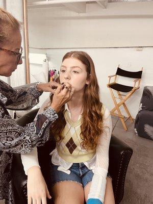 Actress Ella Rouhier getting touched up by makeup artist Lars Bender