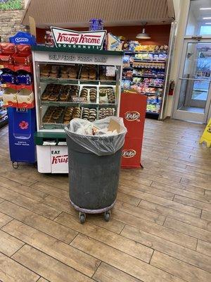 Trash can right in front of the doughnut display.