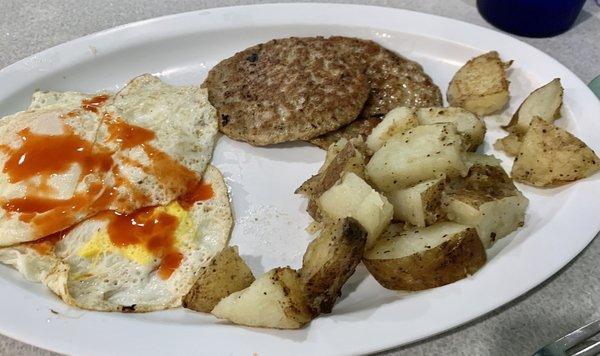 Eggs over medium with hot sauce.  Sausage and home fries.