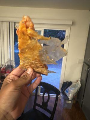 Pizza cooked with paper stuck on it